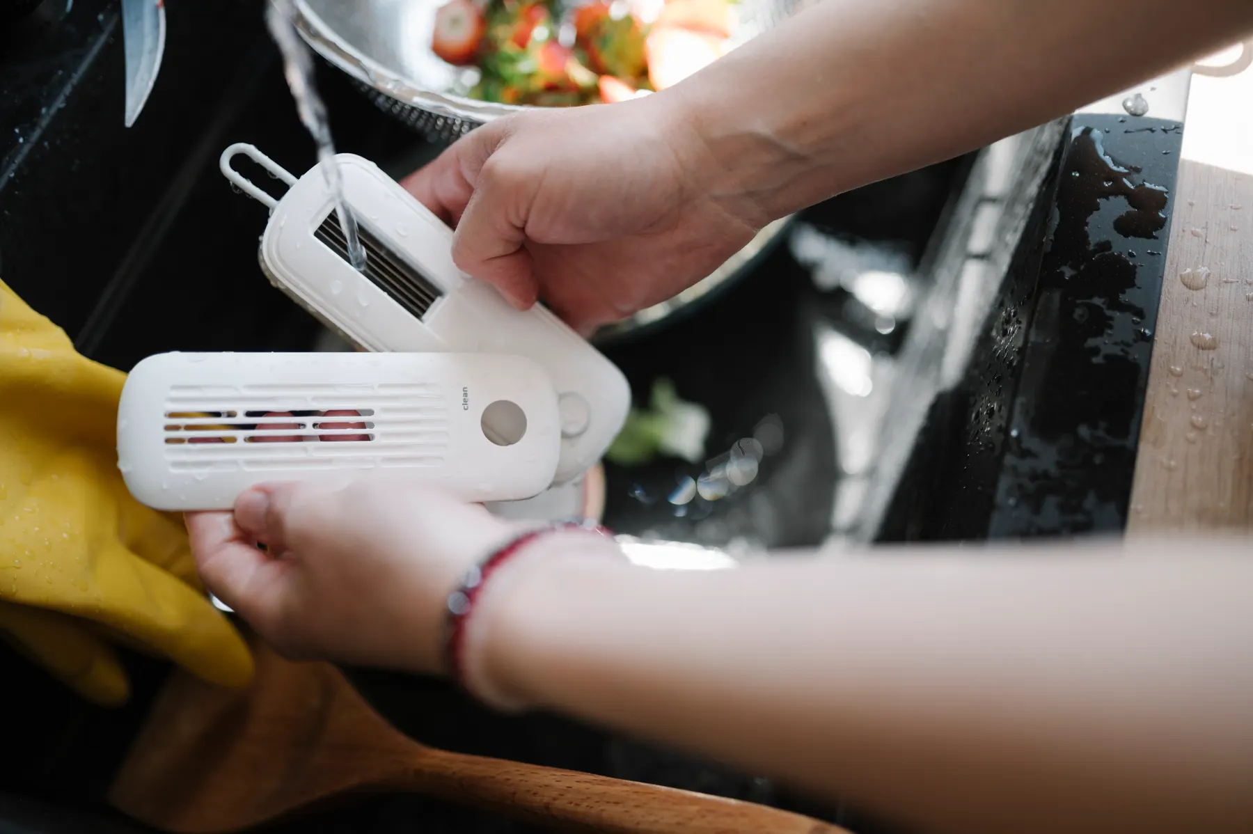 Cleaner in rubber gloves working at a kitchen sink