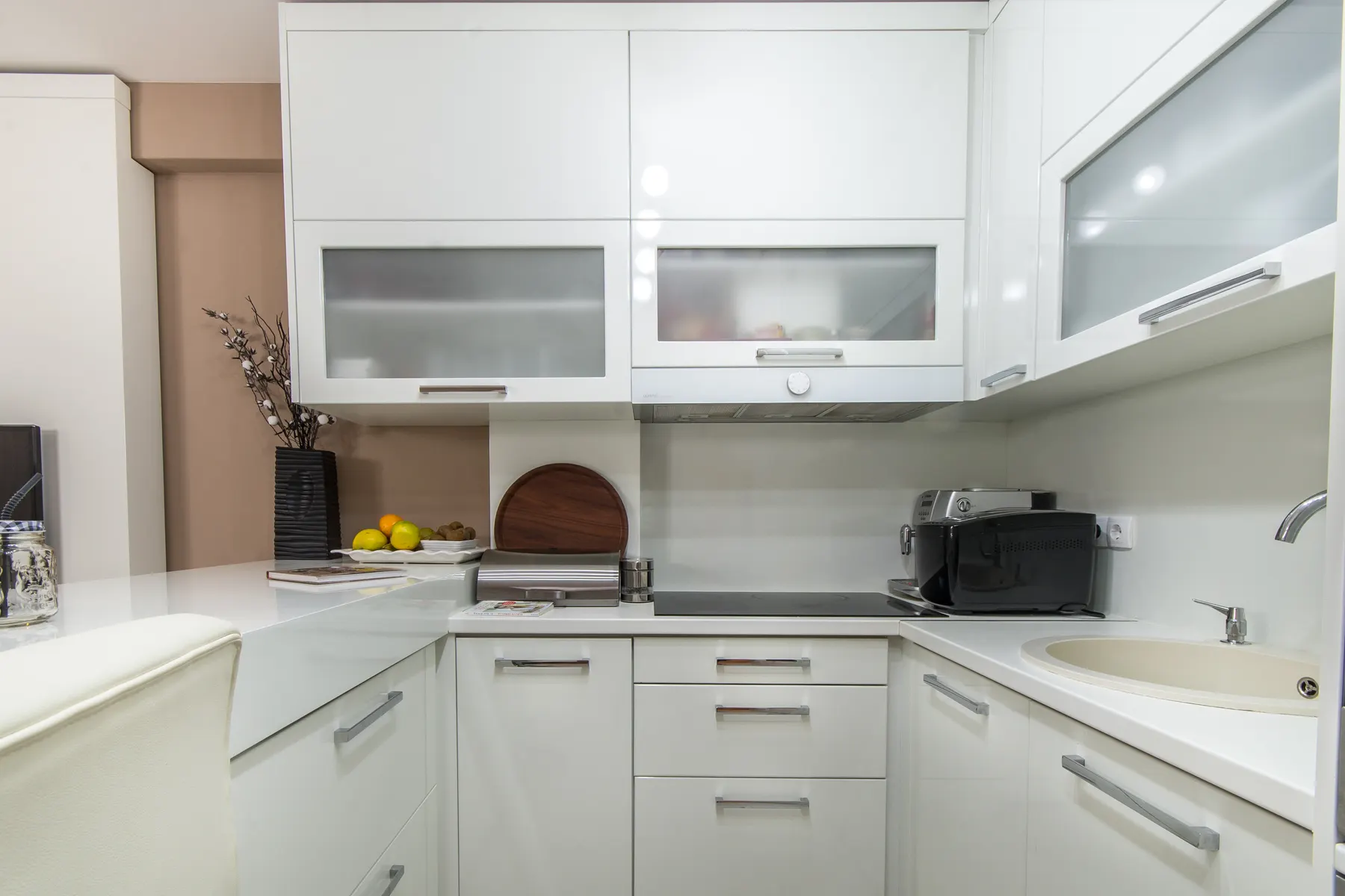 Bright white kitchen with clean, clear countertops after a house cleaning visit